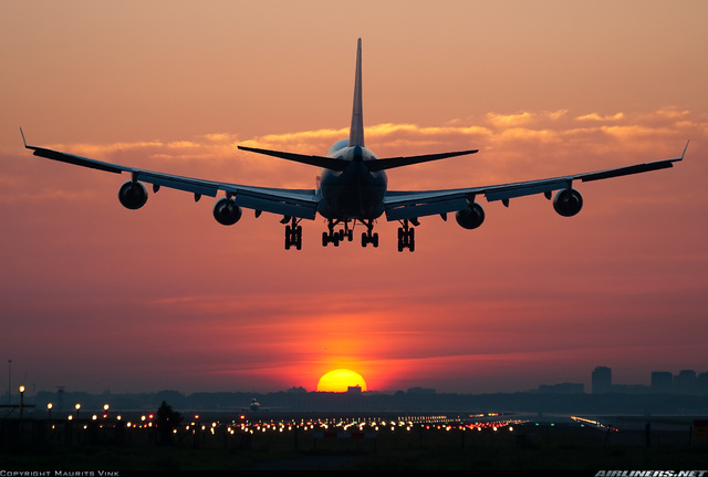Un avión aterrizando al atardecer